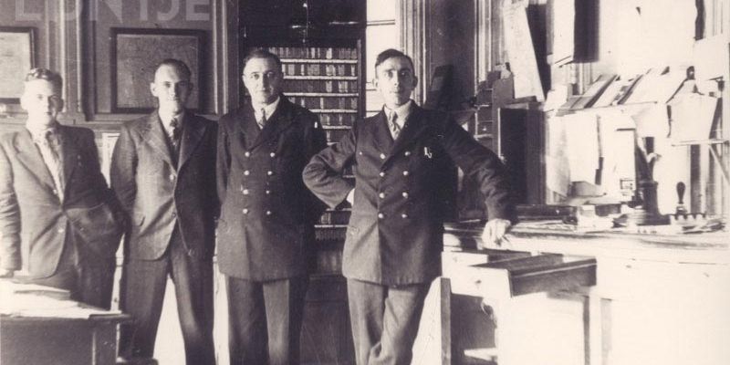 De heren De Vries, Van Smirren, Wienen en Koerts in het kaartjesbureau, station Kampen